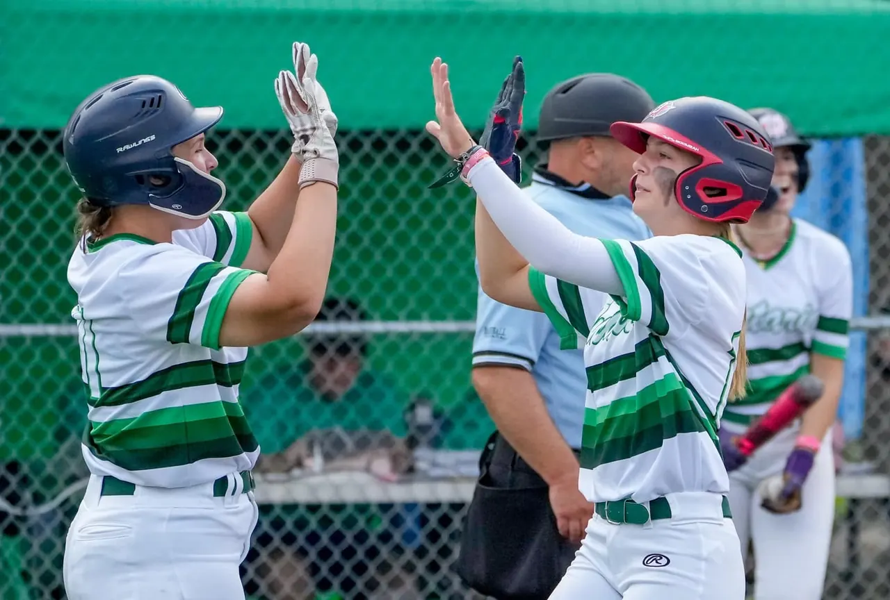 Finleigh Kane high-fiving a Team Ontario teammate after a hit