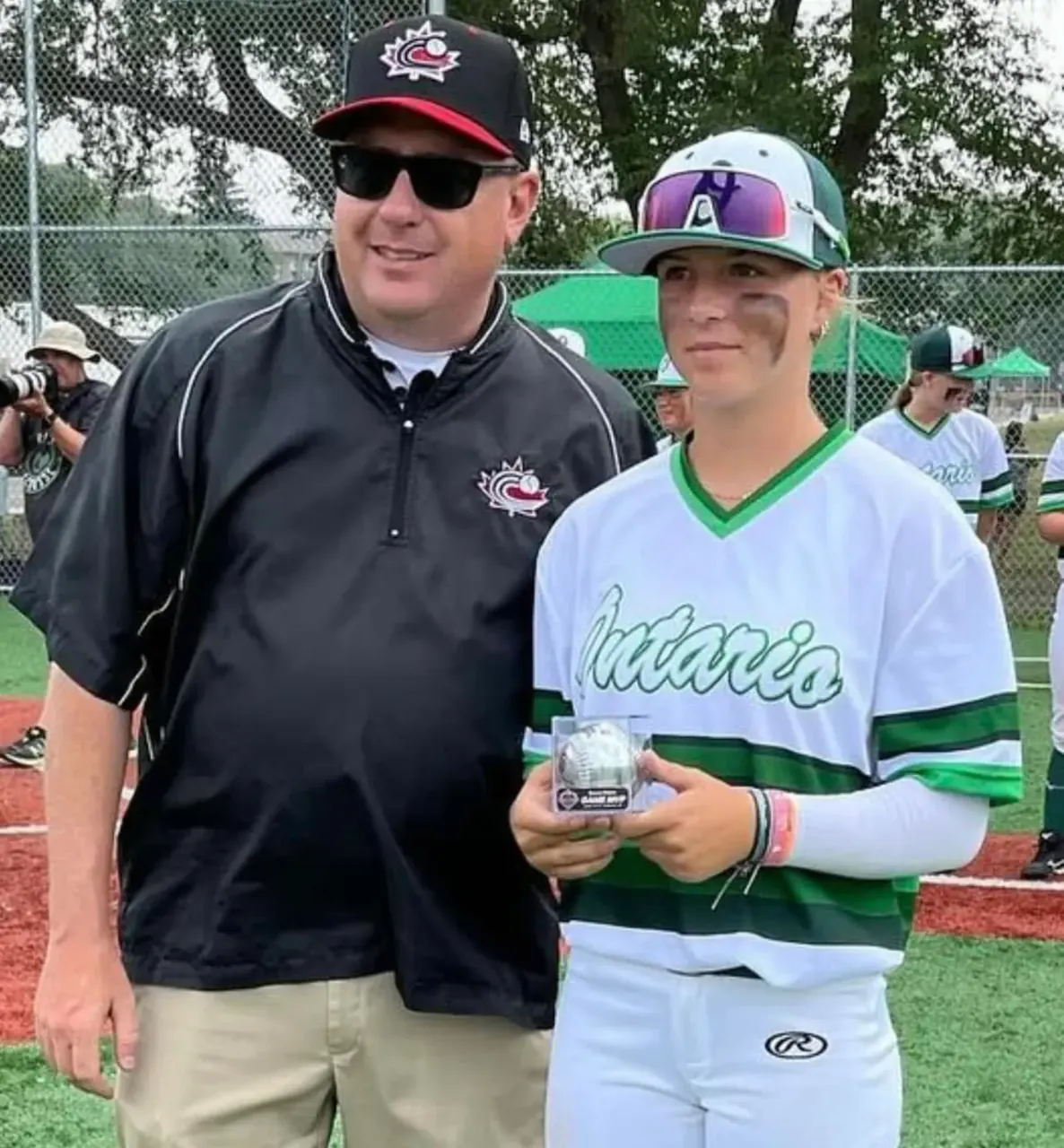 Finleigh Kane in a Team Ontario jersey holding a commemorative baseball